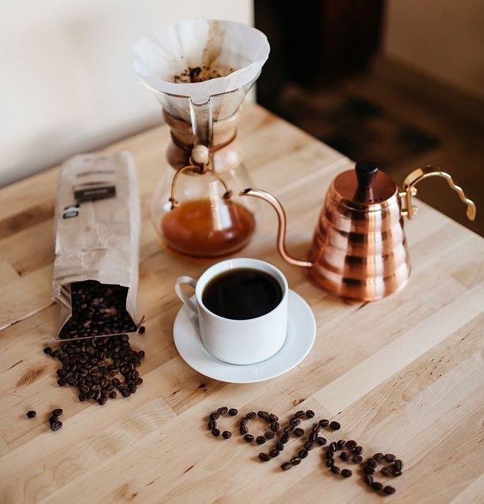 یک فنجان قهوه همراه دانه های قهوه و قهوه جوش