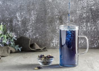 گل پنیرک آبی با نوشیدنی آبی در بک گراند خاکستری