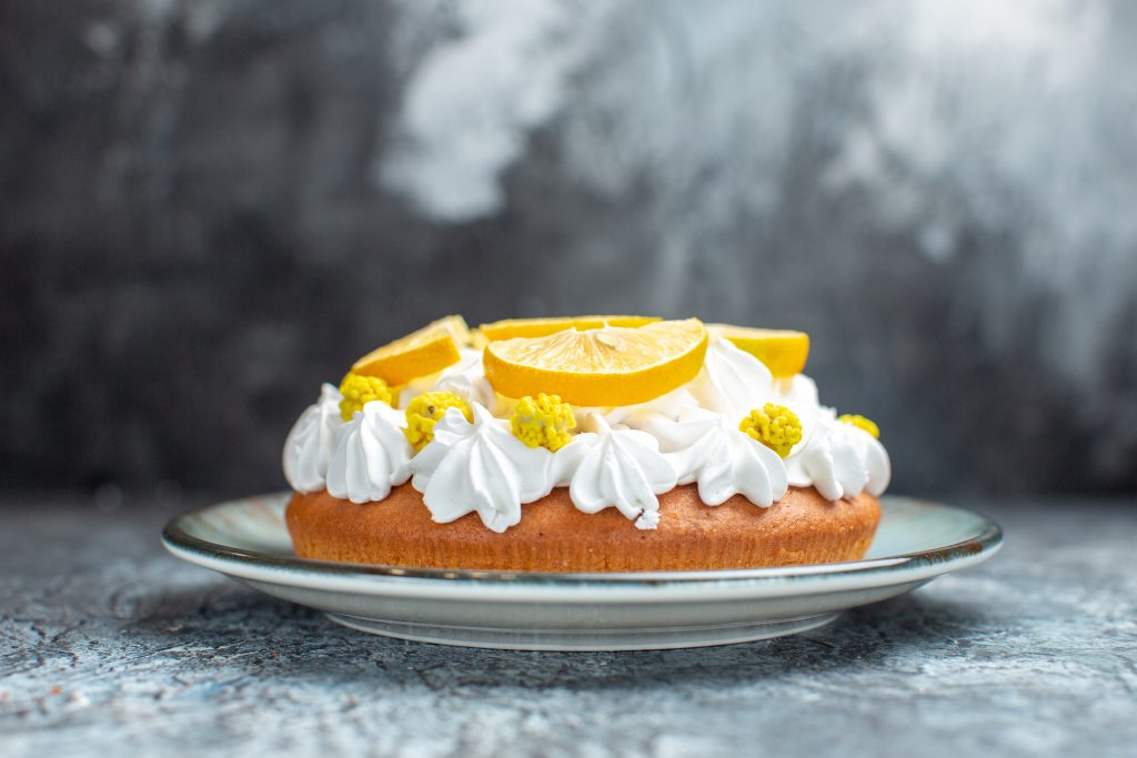 کیک بدون قالب با تزیین خامه و لیمو در بک گراند طوسی